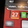 A digital display screen showing a casino betting interface, with text prompting to hurry bets and a highlighted number 27 in red. There are options for betting amounts and a 'share bets' button.